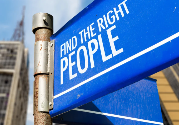 Blue street sign with 'Find the Right People' text against a blurred cityscape background